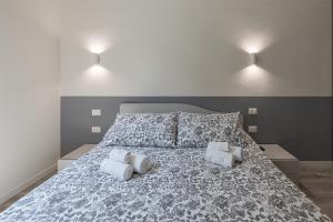 una camera da letto con un grande letto con due cuscini di La Boutique Milano: appartamento in Porta Romana a Milano