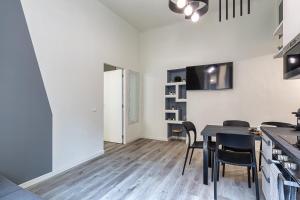 una cucina e una sala da pranzo con tavolo e sedie di La Boutique Milano: appartamento in Porta Romana a Milano