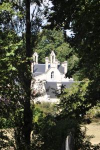 a white house in the middle of some trees at Château du Roc in Saint-Thomas-de-Cônac