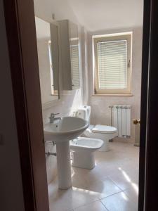 a bathroom with a sink and a toilet and a mirror at Stan u samom centru Obrenovca, na Trgu 2 in Obrenovac