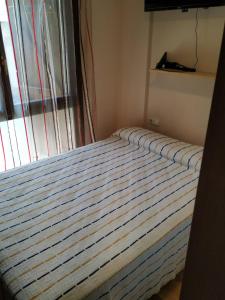 a bed in a bedroom with a striped mattress at Apartamento en escarrilla, sallent de gallego in Sallent de Gállego