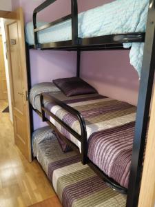 two bunk beds in a small room with a door at Apartamento en escarrilla, sallent de gallego in Sallent de Gállego