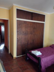 a bedroom with a bed with a large wooden door at Alquileres Viviana in Tandil