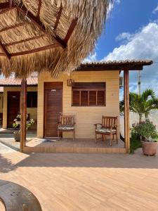 une terrasse avec 2 chaises et une maison dans l'établissement Pousada Rio Aratuá, à Galinhos