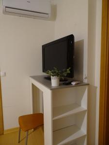 a tv sitting on a table with a tv on it at SUDWEST ROOMS by Stay in Alentejo for HIKERS in Vila Nova de Milfontes