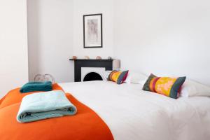a bedroom with a large white bed with towels on it at Coastguard Cottage in Milford on Sea