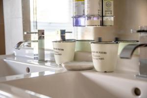 a bathroom sink with two cups on top of it at Coastguard Cottage in Milford on Sea +33 photos