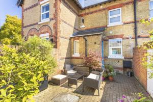 a patio in front of a brick house at Coastguard Cottage in Milford on Sea
