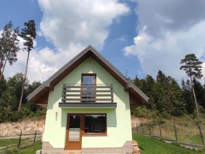 a small house with a balcony on top of it at Domek u Hornika in Dursztyn