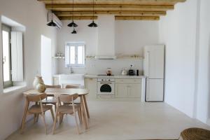 a kitchen with a table and chairs and a refrigerator at Agapi Home in Agápi