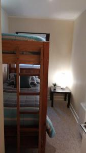 ein Schlafzimmer mit einem Etagenbett und einem Tisch in der Unterkunft DEPARTAMENTOS TERMAS DE CHILLAN in Nevados de Chillan
