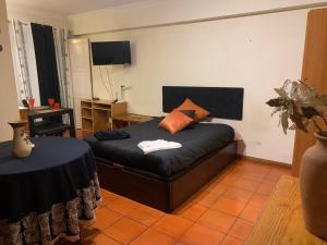 a bedroom with a bed with a table and a desk at Casa da Universidade in Coimbra