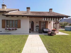 a small white house with a porch and a yard at Villa Bonetti in Costermano