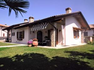 a white house with a porch and a yard at Villa Bonetti in Costermano