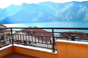 a balcony with a view of the water and mountains at Apartments Risan Club Family in Risan