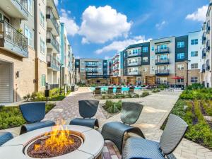 an outdoor patio with chairs and a fire pit in front of apartment buildings at Modern & Chic 1BR Luxury Apts Close to Downtown & Airport in Austin