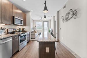 Modern & Chic 1BR Luxury Apts Close to Downtown & Airport في أوستن: مطبخ وغرفة معيشة مع كونتر توب