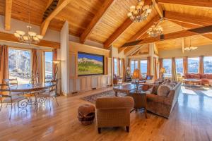 sala de estar con techos de madera, mesa y sillas en Nordic Inn en Crested Butte