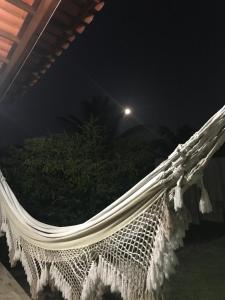 a hammock on the side of a house at night at Pousada Guiné in Mucugê