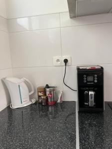 a kitchen counter with a coffee maker and a toaster at Maison spacieuse avec grand jardin et parking à 20min de Lyon in Simandres