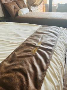 a bed with a brown blanket on top of it at Apartmani Tiske noći in Bečej