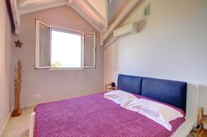 a bedroom with a purple bed and a window at Crystal Beach, vue mer, accès direct plage et piscine, clim in Sèze