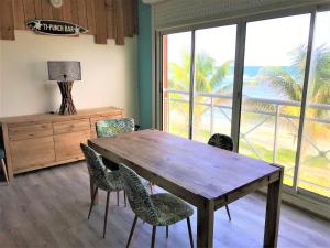 a dining room with a wooden table and chairs at Crystal Beach, vue mer, accès direct plage et piscine, clim in Sèze