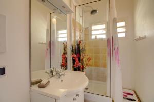 a bathroom with a sink and a mirror at Crystal Beach, vue mer, accès direct plage et piscine, clim in Sèze