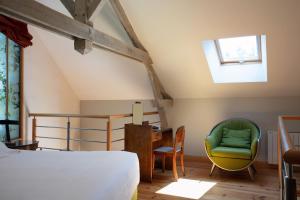 a bedroom with a bed and a table and chairs at Le Jardin des Plumes in Giverny