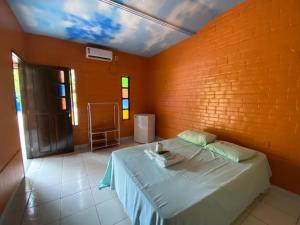 a bedroom with a bed with a brick wall at Chale Praia Residence in São Luís