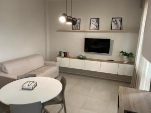 a living room with a couch and a table and a tv at La Favola Apartment Orbassano in Orbassano
