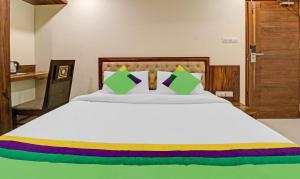 a bedroom with a large white bed with green pillows at Treebo Trend Krishnam Boutique in Bangalore