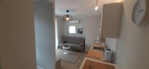 a living room with a couch and a clock on the wall at Oasis, Old Town Apartment in Elblag