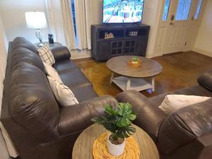 a living room with a brown leather couch and a table at Villa 7 in Hammond