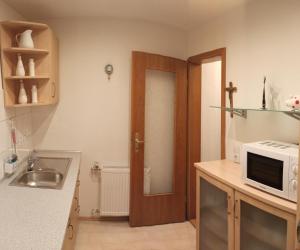 a kitchen with a door and a sink and a microwave at Ferienwohnung Frank in Passau