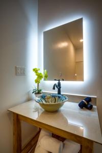 a bathroom with a sink and a mirror at The Sea Glass Inn in Placencia Village