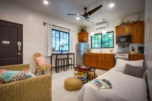 sala de estar con cama y cocina en The Sea Glass Inn, en Placencia Village