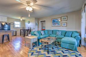 ein Wohnzimmer mit einem blauen Sofa und einem Tisch in der Unterkunft Lovely Dauphin Island Cottage with Deck and Gulf Views in Dauphin Island