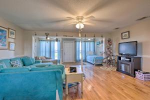 uma sala de estar com um sofá azul e uma televisão em Lovely Dauphin Island Cottage with Deck and Gulf Views em Dauphin Island