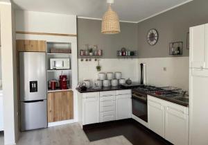 a kitchen with white cabinets and a white refrigerator at VILLA TIEGO in Medulin