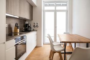 a kitchen with a wooden table and a dining room at Ko-Living - Gaming Suite am Alten Markt - Altstadt - 6P in Halle an der Saale