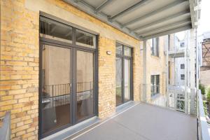 - un balcon avec des portes coulissantes en verre dans un bâtiment en briques dans l'établissement Ko-Living - Gaming Suite am Alten Markt - Altstadt - 6P, à Halle-sur-Saale