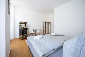 a bedroom with a bed and a table and chairs at Ko-Living - Gaming Suite am Alten Markt - Altstadt - 6P in Halle an der Saale