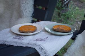 two pieces of cake sitting on plates on a table at Glempings Eglenieki 