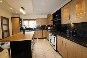 a large kitchen with wooden cabinets and black counter tops at St Ann's House in Rotherham