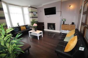 a living room with a black couch and a fireplace at St Ann's House in Rotherham