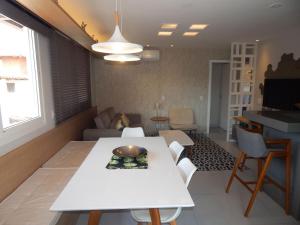Una sala de estar con una mesa y sillas blancas. en Linda e aconchegante casa a 400m da Praia de Geribá com Piscina - B35, en Búzios