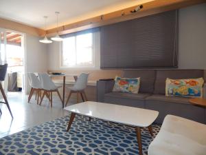een woonkamer met een bank en een tafel en stoelen bij Linda e aconchegante casa a 400m da Praia de Geribá com Piscina - B35 in Búzios