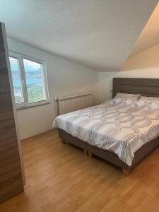 a bedroom with a bed and two windows at Villa Aurora in Ohrid