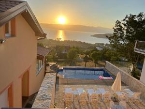 a villa with a swimming pool and a sunset at Villa Aurora in Ohrid